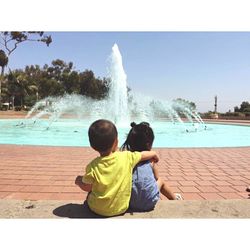 Rear view of friends enjoying in swimming pool