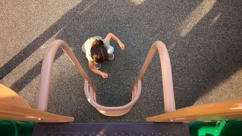 Directly above shot of girl playing on jungle gym at park