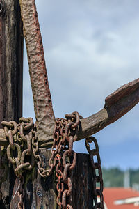 Close-up of rusty chain against sky