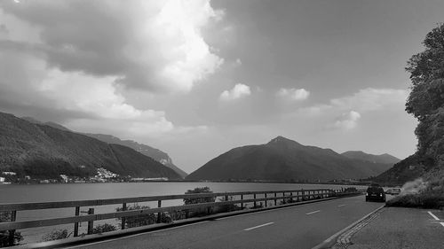 Road by mountains against sky