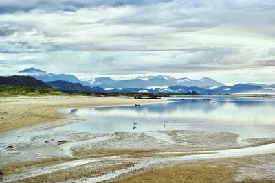 Scenic view of lake by mountains against sky