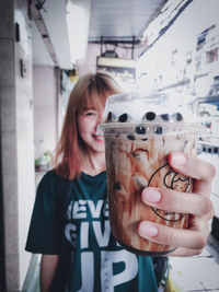 Portrait of a smiling young woman holding drink