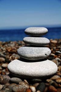 Stack of pebbles on beach against sky