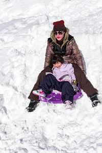 High angle view of woman sitting on snow