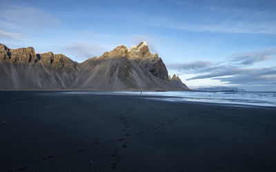 Scenic view of sea and mountains against sky