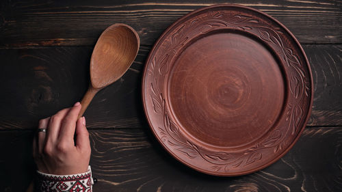 Cropped hand of woman holding plate on table