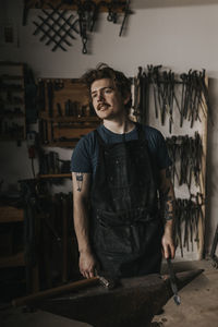 Male blacksmith using hammer and anvil