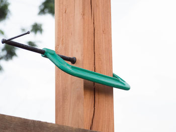 Close-up of c clamp on wood against sky