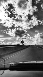 Road passing through landscape against cloudy sky