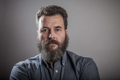 Portrait of bearded man against gray background