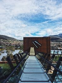 View of bridge in city against cloudy sky