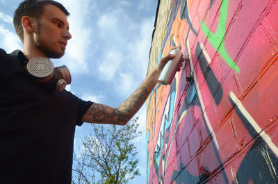 Low angle view of man standing against wall