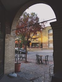 Trees and tables in city against sky