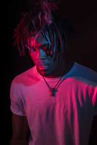Portraits of beautiful african young man under blu and red lights