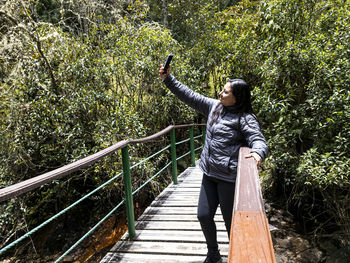 Natural moments woman and river in harmony, woman taking a selfie