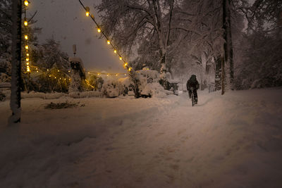 People on snow against sky at night