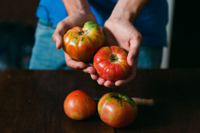 Midsection of man holding apple on table