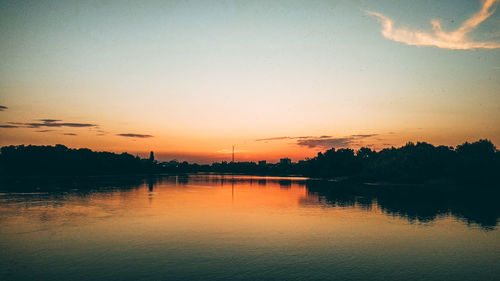 Scenic view of lake against orange sky