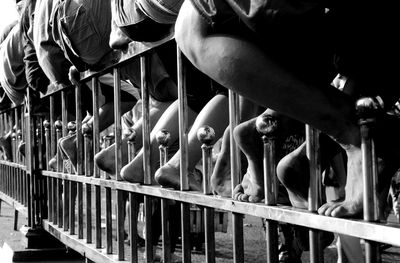 Low section of people sitting on railing