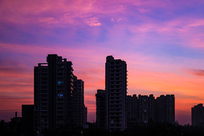 Silhouette buildings against sky during sunset
