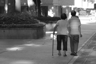 Rear view of man walking on road