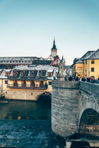 Bridge over river against buildings in city