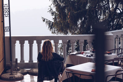 Rear view of woman standing by railing