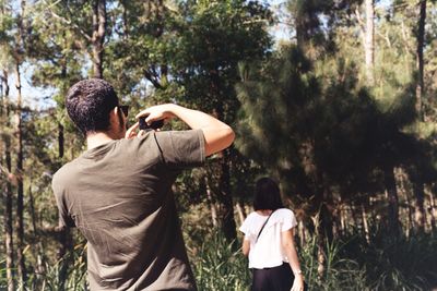 Rear view of father with daughter against trees