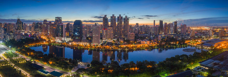 Aerial view of illuminated buildings in city against sky