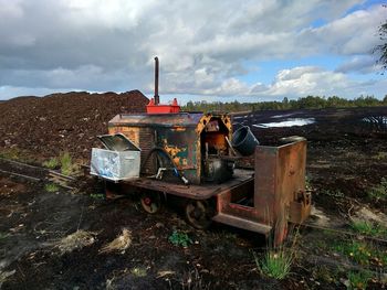 Abandoned truck on field against sky