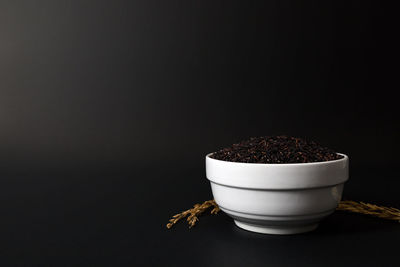 Close-up of tea cup on table against black background