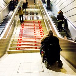 Rear view of man standing on escalator