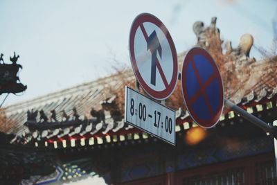 Low angle view of information sign against sky