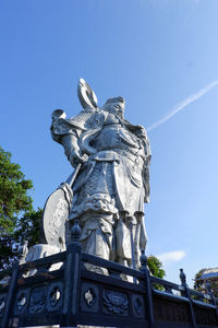 Low angle view of statue against blue sky