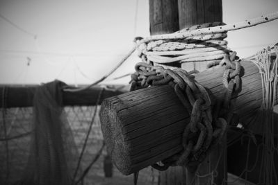 Close-up of rope tied on wooden post in sea