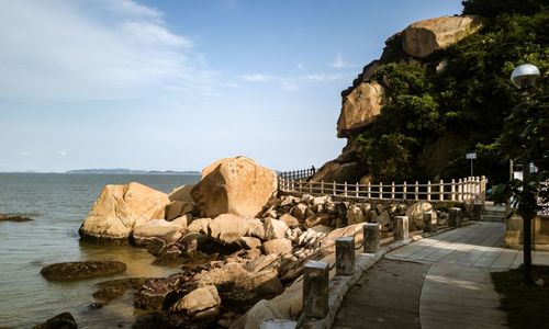 Panoramic shot of rocks by sea against sky