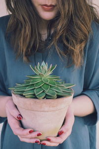 Midsection of woman holding plant