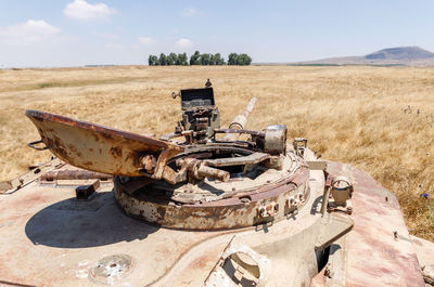 Old abandoned truck on field against sky