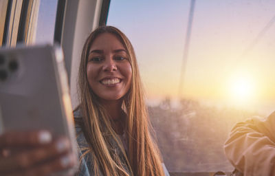 Young tourist sitting on the cableway in caracas enjoying a photo taken on her smartphone. 