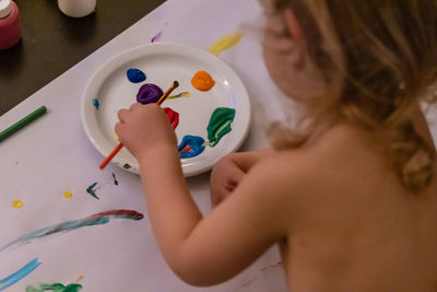 High angle view of girl painting on table