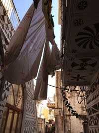 Low angle view of clothesline hanging by house