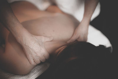 Low section of woman sitting on bed
