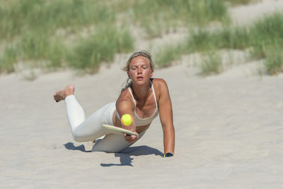 Full length of woman sitting on beach