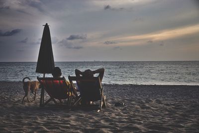 Chairs on beach against sky