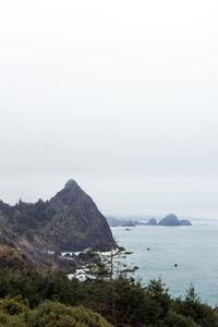 Scenic view of sea and mountains against sky