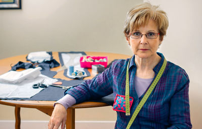 Portrait of mid adult woman wearing eyeglasses on table