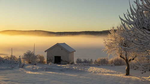 Lake bysjön in grangärde sweden when the fog is close to ground and the sun shines through the fog