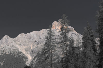 Low angle view of snowcapped mountain against sky during winter