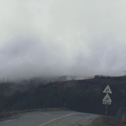 Road sign against sky