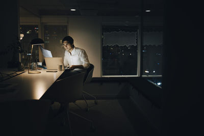 Businessman working late in dark creative office